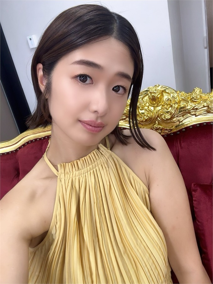 Nanami Kawakami ในเดรสสีทองบนเก้าอี้กำมะหยี่แดง